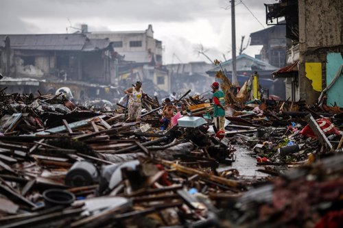 Un superviviente camina por una zona devastada por el tifón 'Yolanda' en Tacloba
