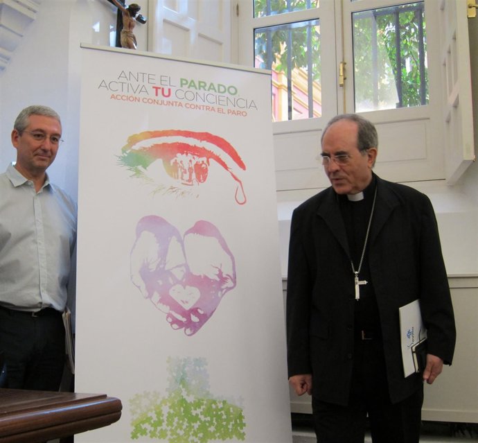 El arzobispo de Sevilla, Juan José Asenjo, junto al cartel de la campaña