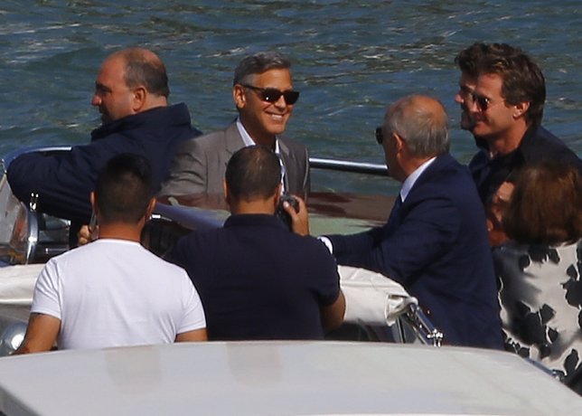 U.S. Hollywood star George Clooney (2nd L) smiles as he stands in a boat upon ar