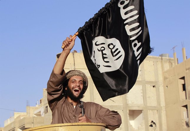 Miliciano islamista yihadista ondeando una bandera del Estado Islámico