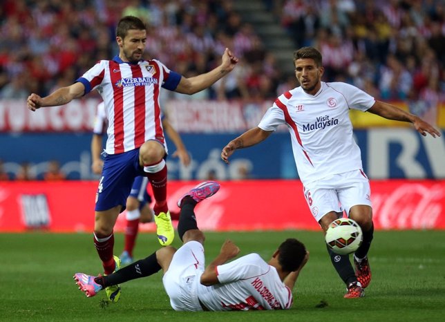 Gabi ante Kolo y Carriço en el Atlético-Sevilla