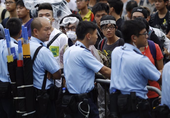 Policías apostados delante de manifestantes junto a Gobierno de Hong Kong