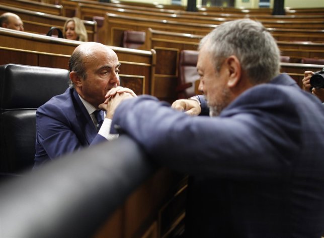 Luis De Guindos, hablando con el nacionalista Pedro Azpiazu