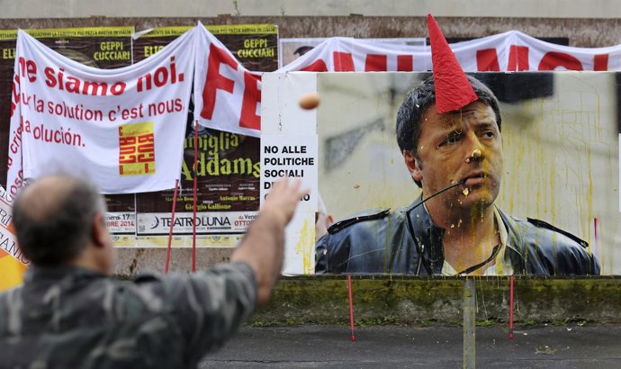 Manifestantes lanzan huevos contra foto de Renzi en Milán