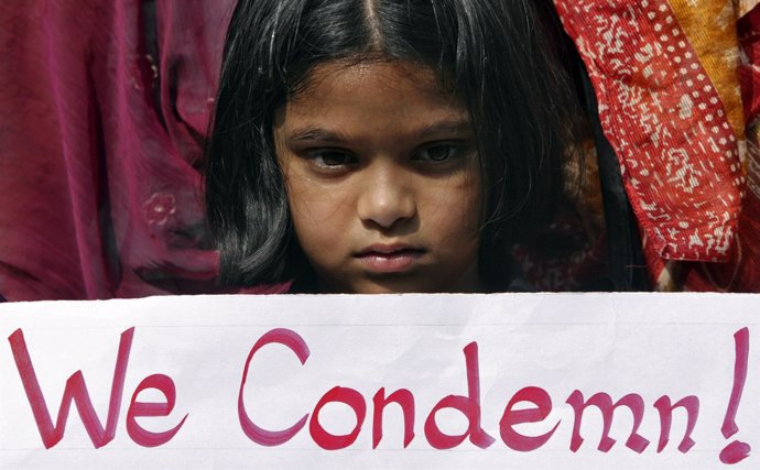 Niña con pancarta en una protesta contra la violencia contra la mujer en India