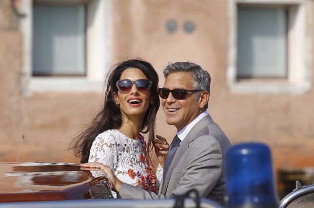 U.S. Actor Clooney and his wife Alamuddin stand in a water taxi on the Grand Can