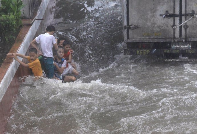 Niños en Manila tras el paso de una tormenta tropical