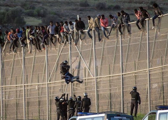 Inmigrantes encaramados en la valla de Melilla