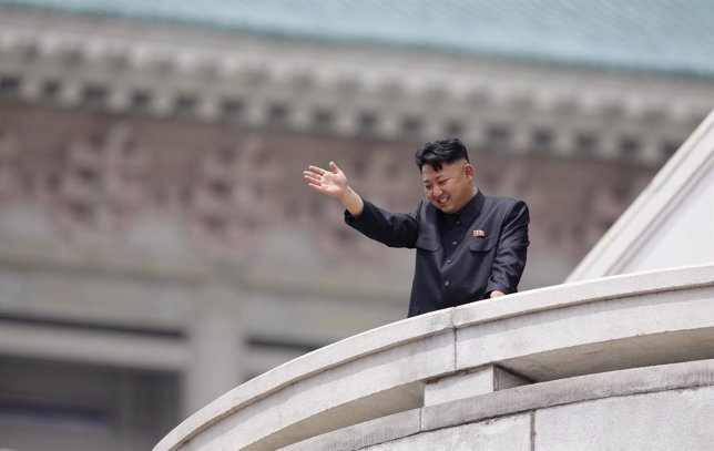 Kim Jong-Un saluda desde un balcón.