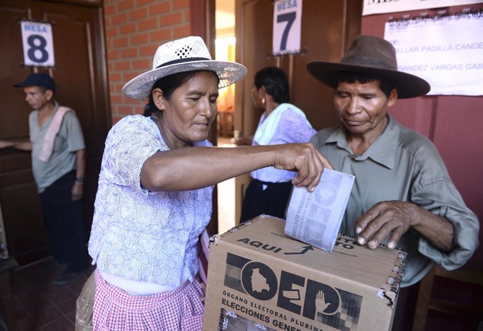 A woman deposits her ballot during the presidential election in Villa 14 de Sept
