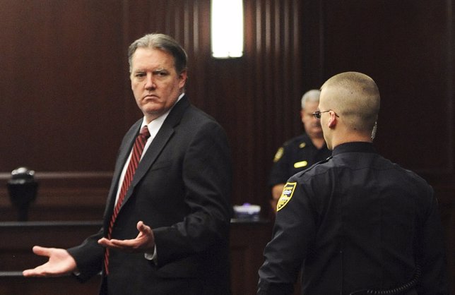 Michael Dunn raises his hands in disbelief as he looks toward his parents after 