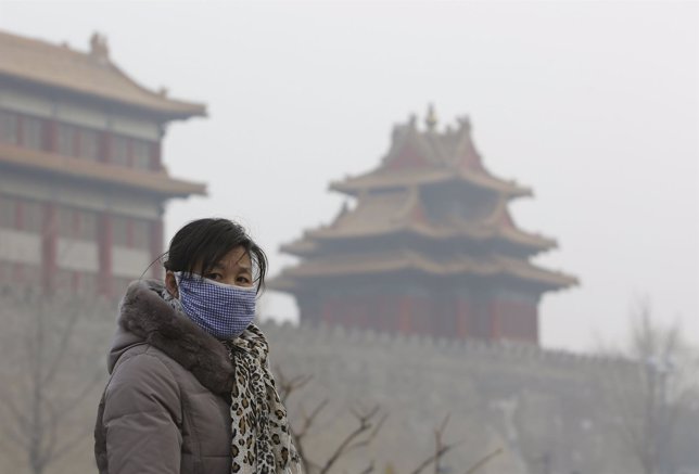 Mujer en China con contaminación aérea