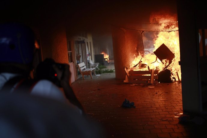 A news photographer takes pictures of a fire at the Municipal Palace during a de