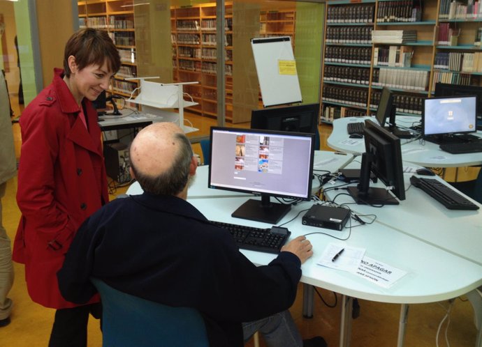 La concajal Domi Fernández conversa con un usuario de Internet en una biblioteca