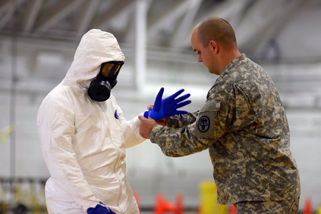 Un militar estadounidense ayuda a otro a ponerse un traje contra el ébola