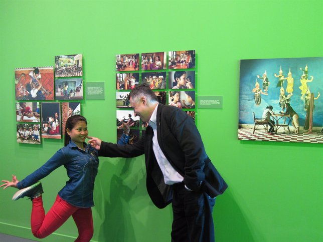 Gervasio Sánchez en la exposición, junto a una de las niñas camboyanas