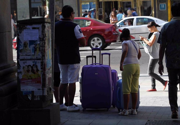 Turismo, turistas, personas en la calle con maletas
