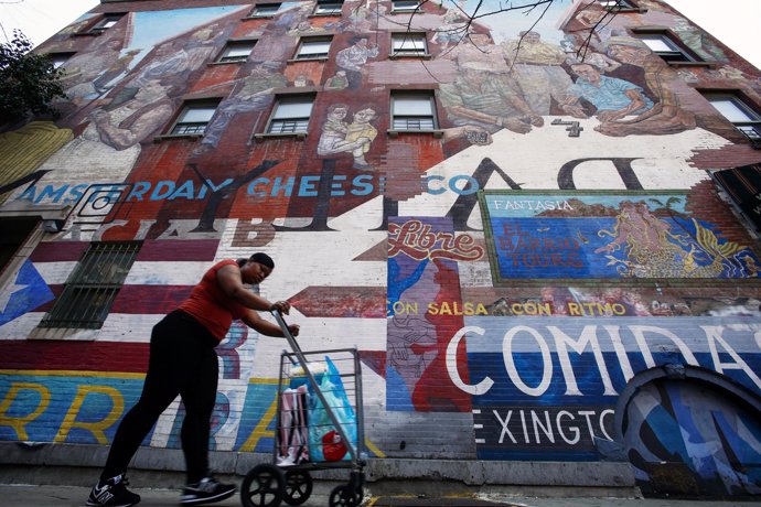 Una mujer hispana pasea por el barrio de Harlem, en Nueva York
