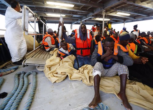 Inmigrantes ilegales siendo atendidos por efectivos sanitarios en alta mar.