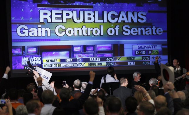 Republican supporters cheer as a giant TV screen displays the results of the Sen