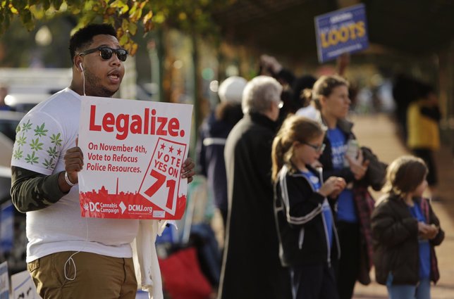 Melvin Clay of the DC Cannabis Campaign holds a sign urging voters to legalize m