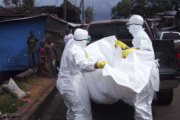Trabajadores sanitarios retiran el cuerpo de una posible víctima de ébola