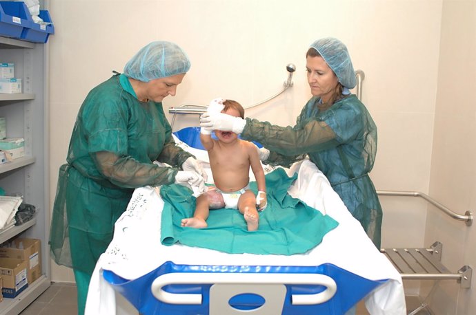 La doctora Paredes y una enfermera realizan curas a un bebé con quemaduras