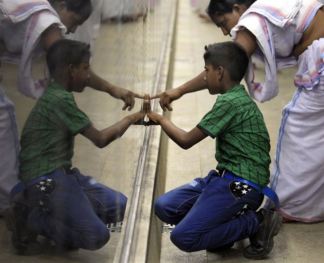 Una madre muestra a su hijo el nombre de su padre en un memorial en Sri Lanka.