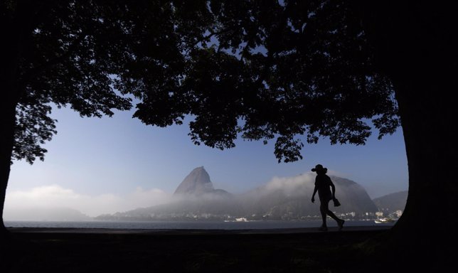 A woman is silhouetted against the backdrop of the sugar loaf mountain in Rio de