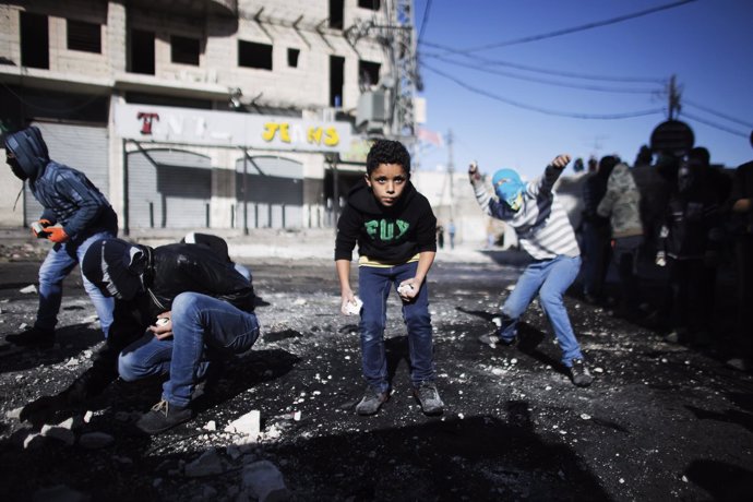 Jóvenes palestinos lanzan piedras contra policías israelíes