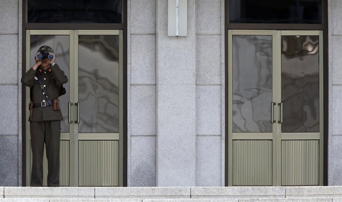 Un soldado norcoreano observa a través de unos prismáticos en la frontera.