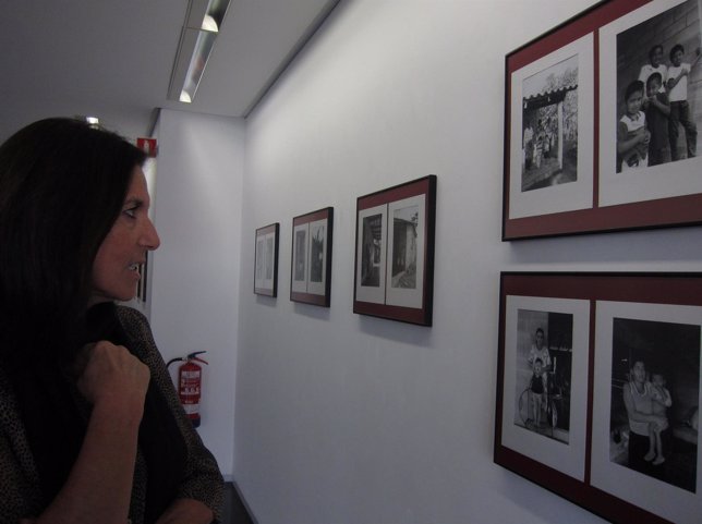 Una mujer contempla algunas de las fotos de la exposición