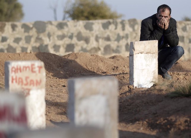 Un kurdo llora ante la tumba de fallecidos en la lucha contra Estado Islámico