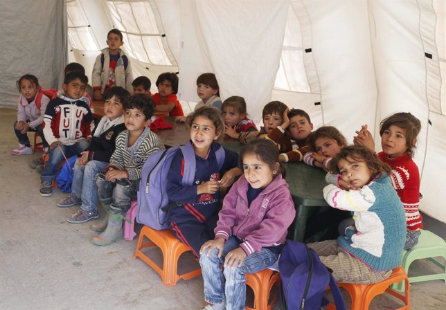 Syrian refugee children attend a class inside a makeshift school, supported by U
