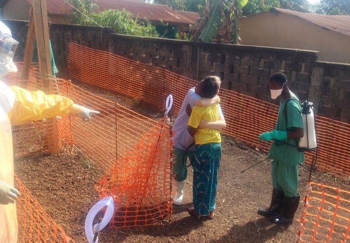Una mujer se abraza al personal sanitario tras superar el ébola en Guinea
