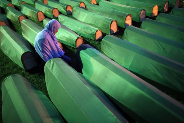 Una mujer bosnia musulmana reza ante un ataúd de un familiar 