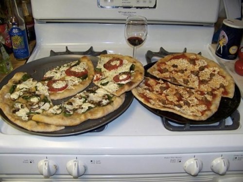 Generado por el 'software' :“Two pizzas sitting on top of a stove top oven”