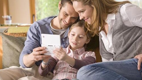 Padres e hijos jugando a la consola Nintend DS