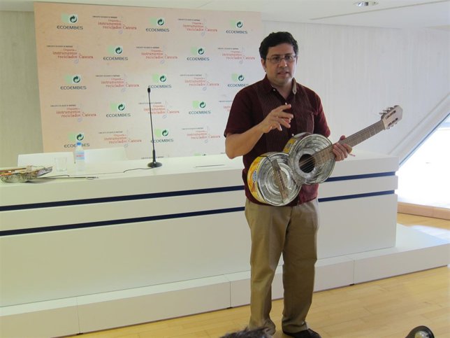 El director de la orquesta muestra uno de los instrumentos reciclados