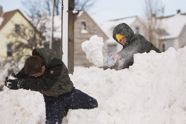 Children play in a snow pile in Buffalo, New York