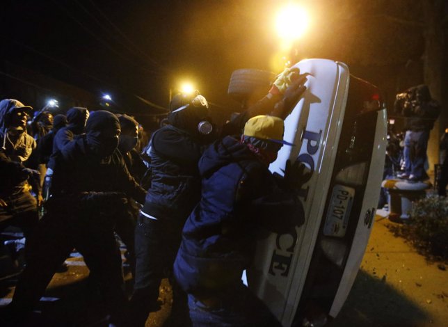 Manifestantes atacan un coche de Policía en Ferguson