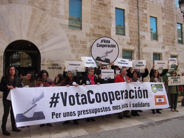 Miembros de ONGD protestan frente a Les Corts por los recortes en Cooperación