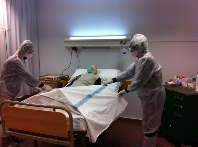 Dos profesionales con el traje explican cómo trabajar con un paciente con ébola
