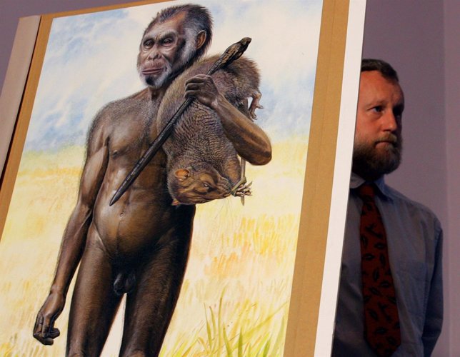 Australian Museum scientist Paul Tacon stands next to a life-size drawing of a n