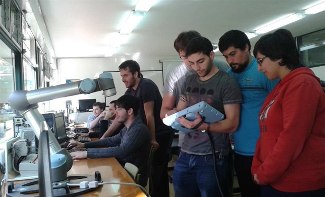 Un grupo de alumnos maneja el robot colaborativo instalado en el centro. 