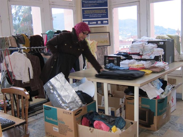 Una voluntaria, ordenando ropa donada en la Fundación Cauce