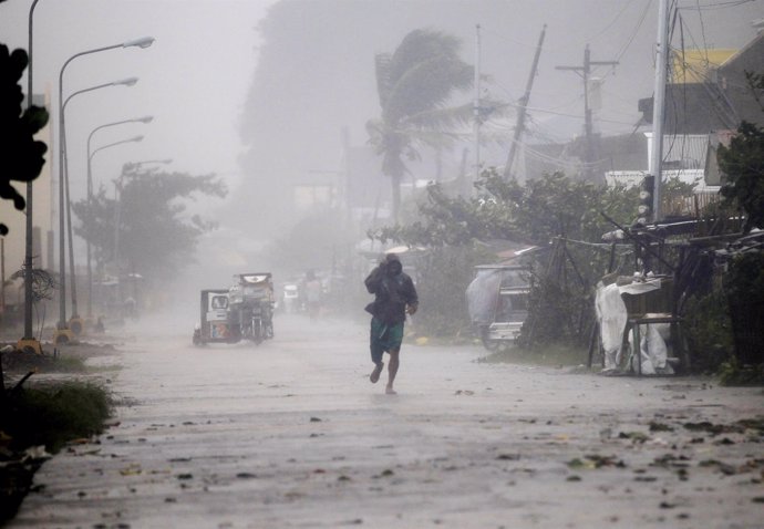 Un hombre caminando en medio de la lluvia provocada por 'Hagupit'