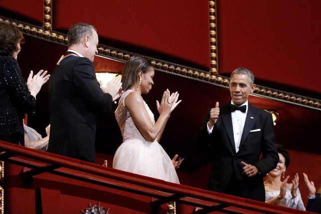Obama gives a thumbs-up as he and the first lady arrive in their box to celebrat