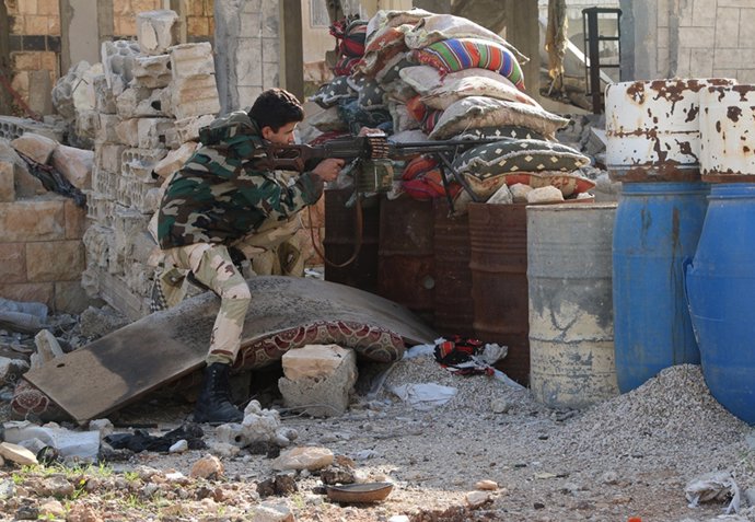 Rebelde sirio dispara tras una cobertura a las fuerzas de Al Assad.