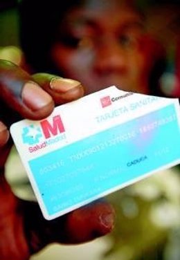 Un joven africano sujeta en susmanos una tarjeta sanitaria rota